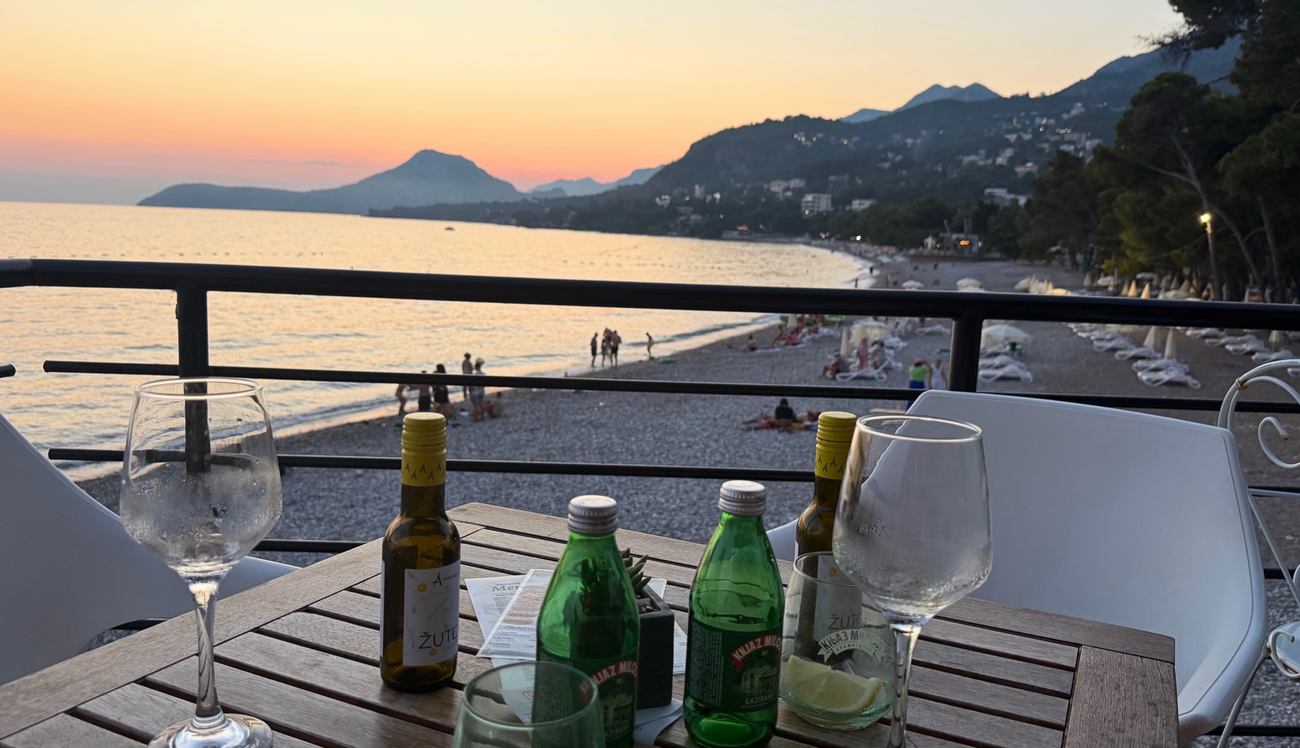 A sunset table above Šušanj Beach with wine and mineral water.