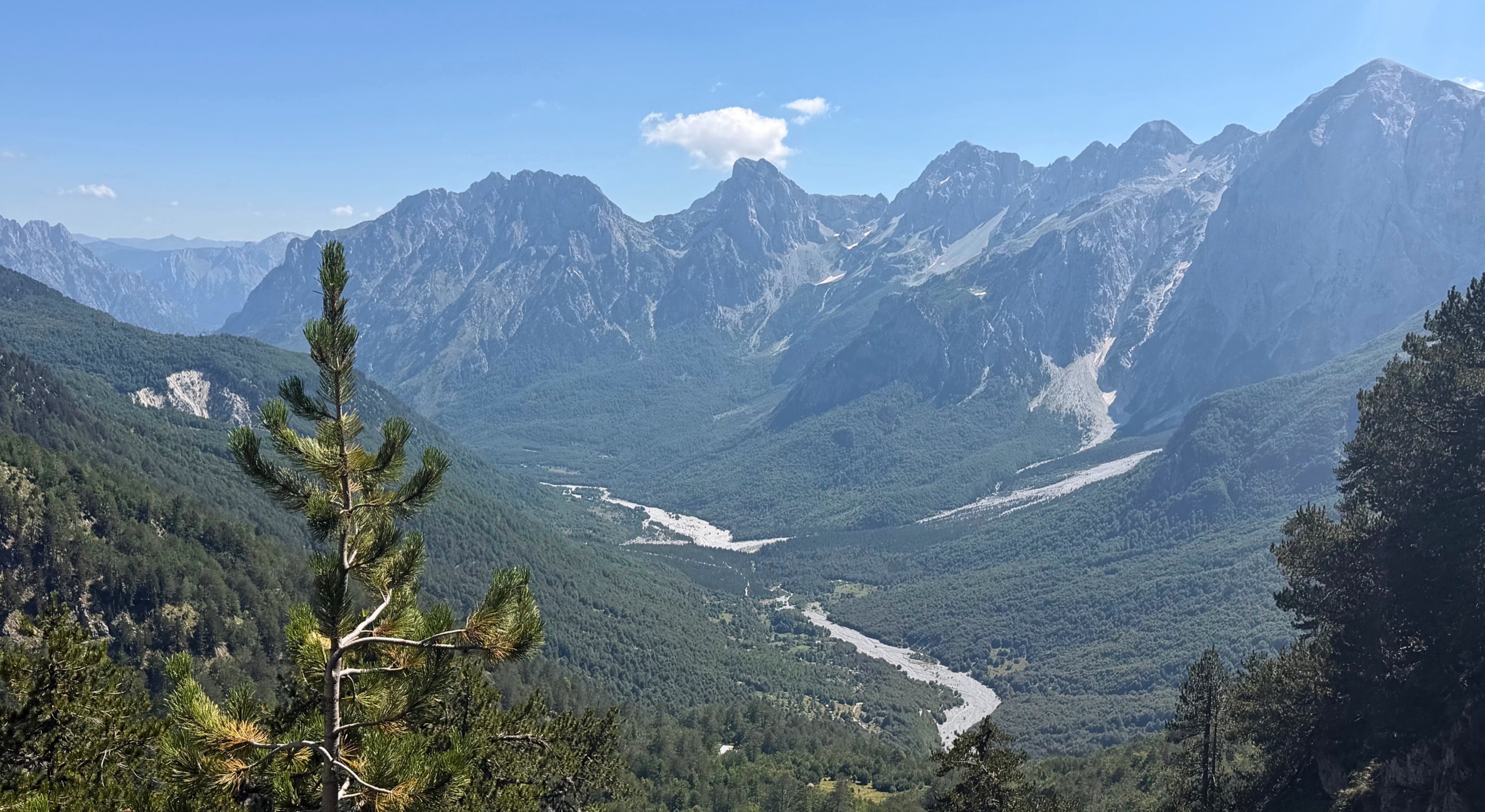 The Valbona Valley below the trail with the Accursed Mountains rising around the route toward Valbona Pass.