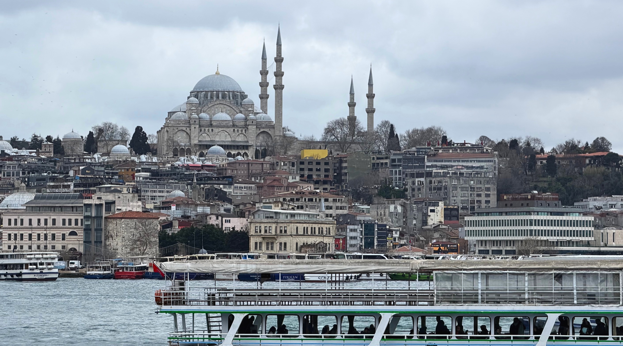 A mosque and hillside buildings seen across the water from an Istanbul ferry.