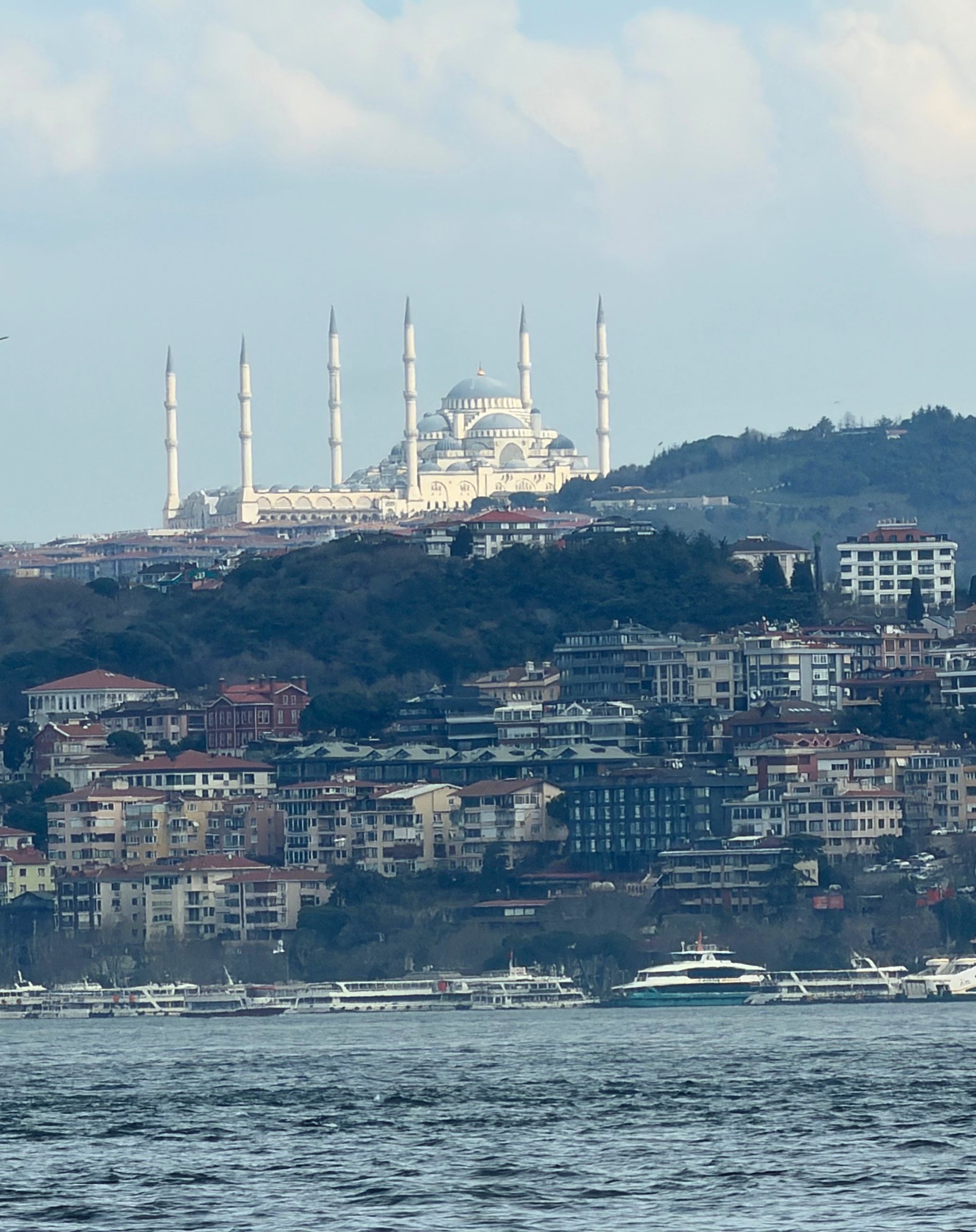 The Blue Mosque seen from across the water, luminous above hillside buildings and the Bosphorus.