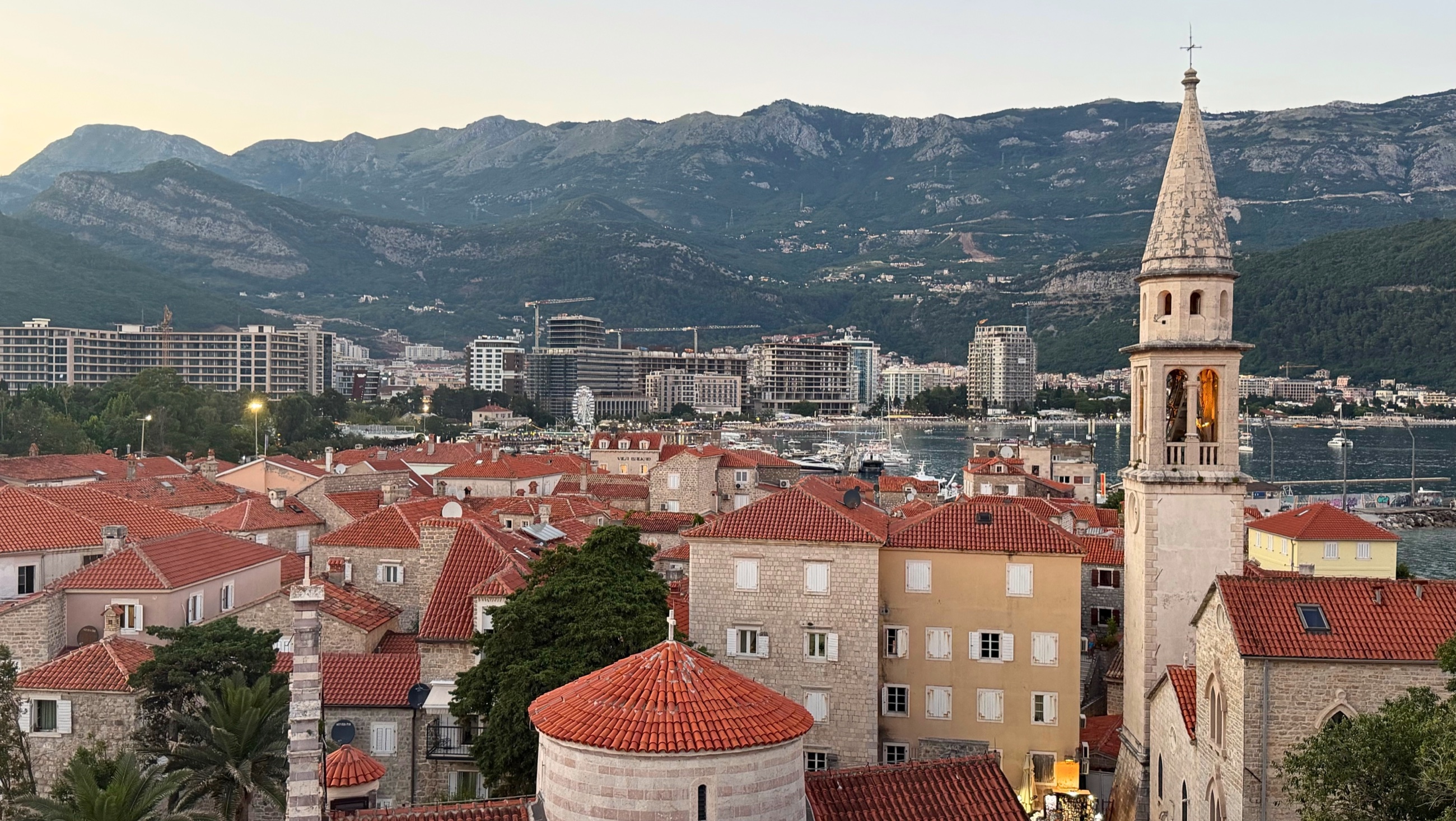 Budva seen from the Citadel, with the old town in the foreground and modern Budva beyond as evening arrives over the coast