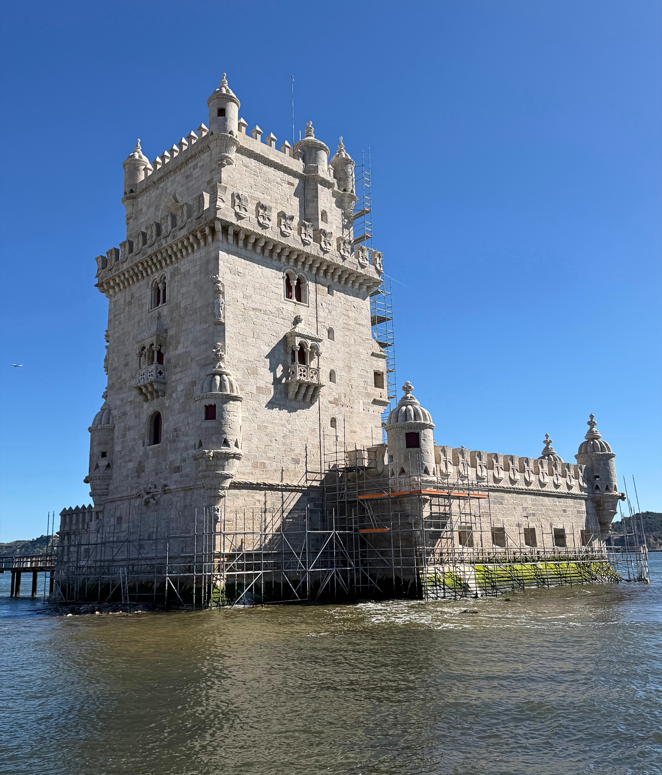 Belém Tower standing at the edge of the Tagus river.