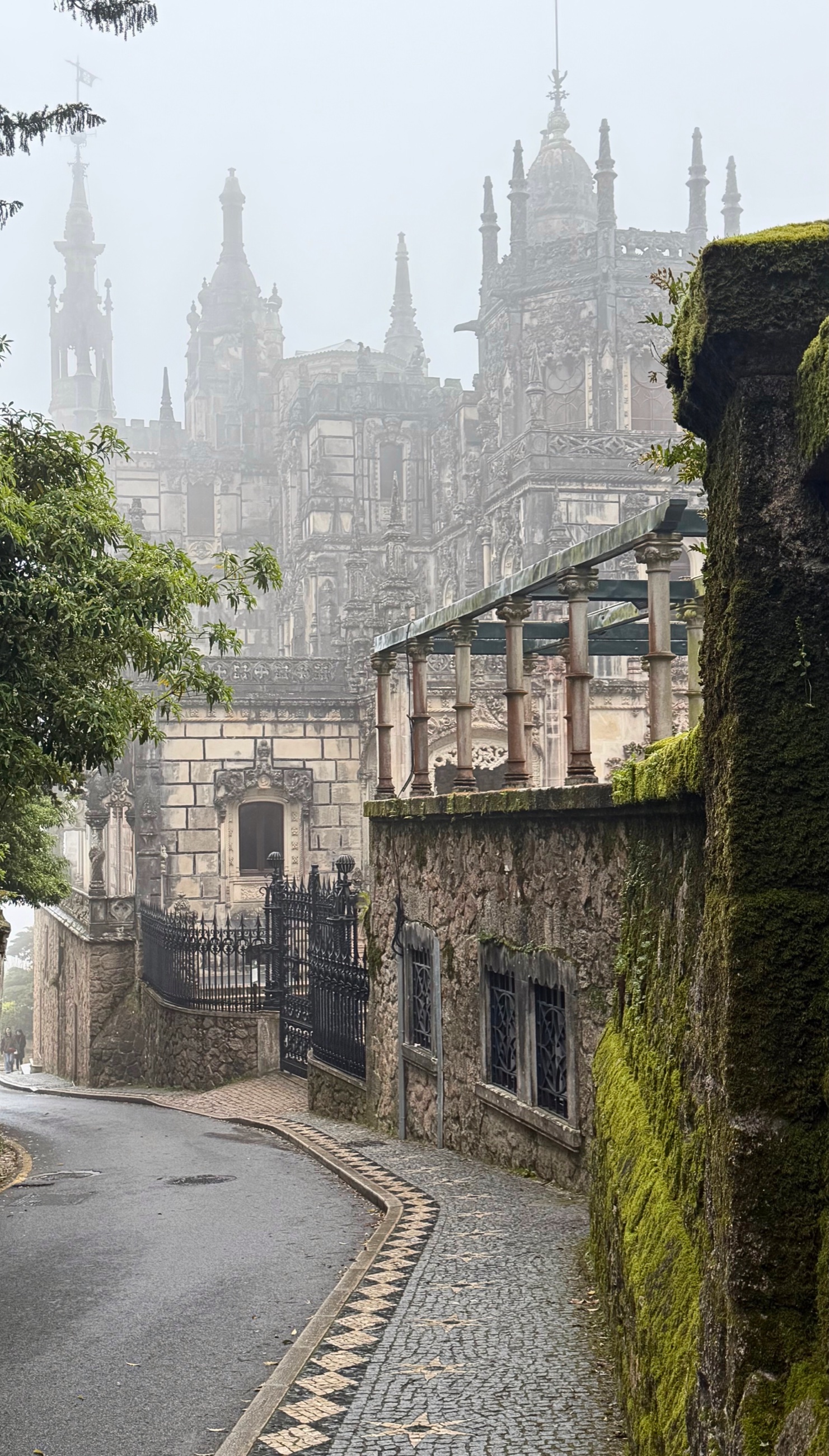 Quinta da Regaleira in Sintra seen through mist and trees.