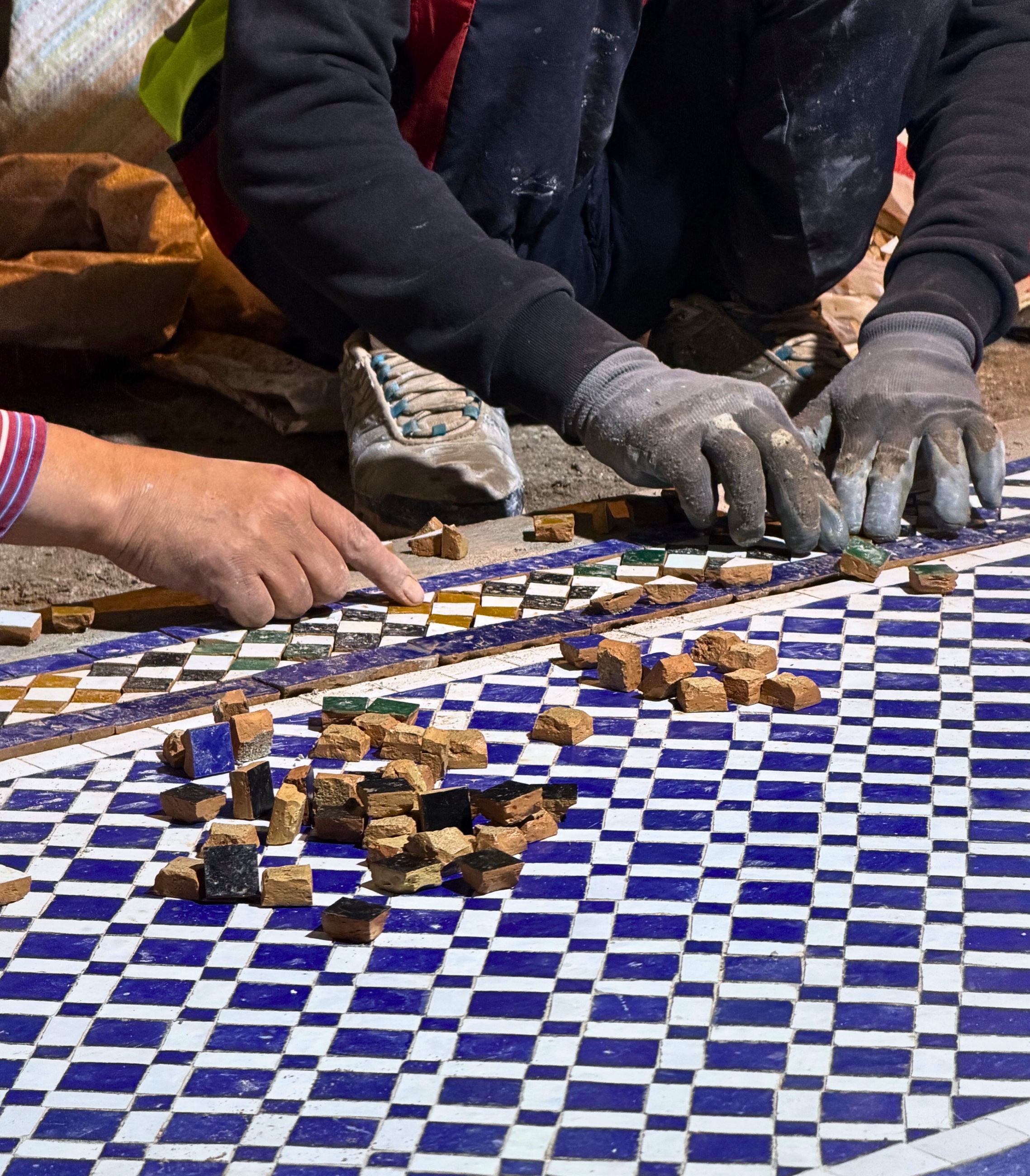 A close view of Moroccan mosaic tilework made from small hand-set pieces.