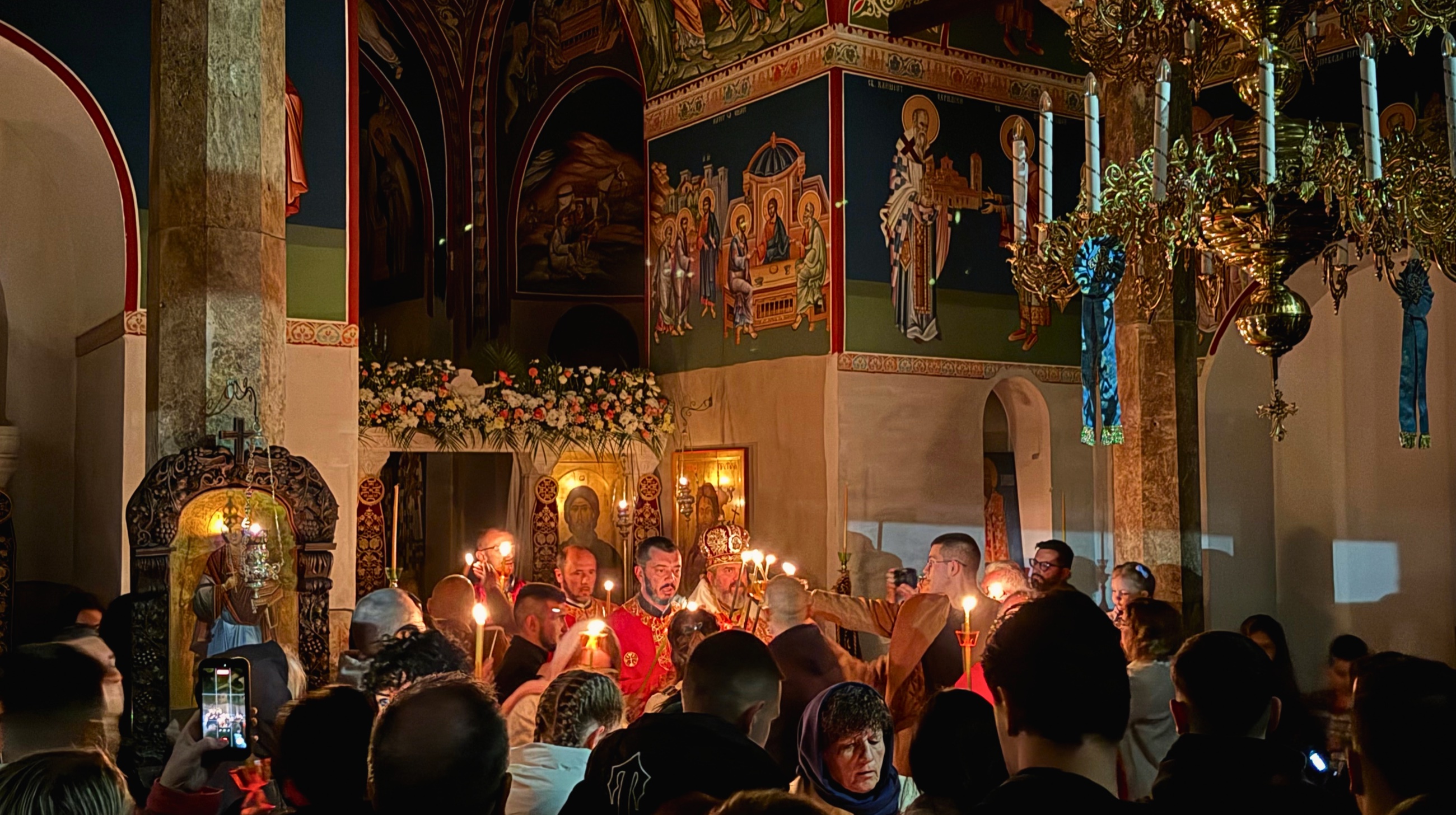 Priests and worshippers holding candles inside the Orthodox Easter service at Plaošnik.