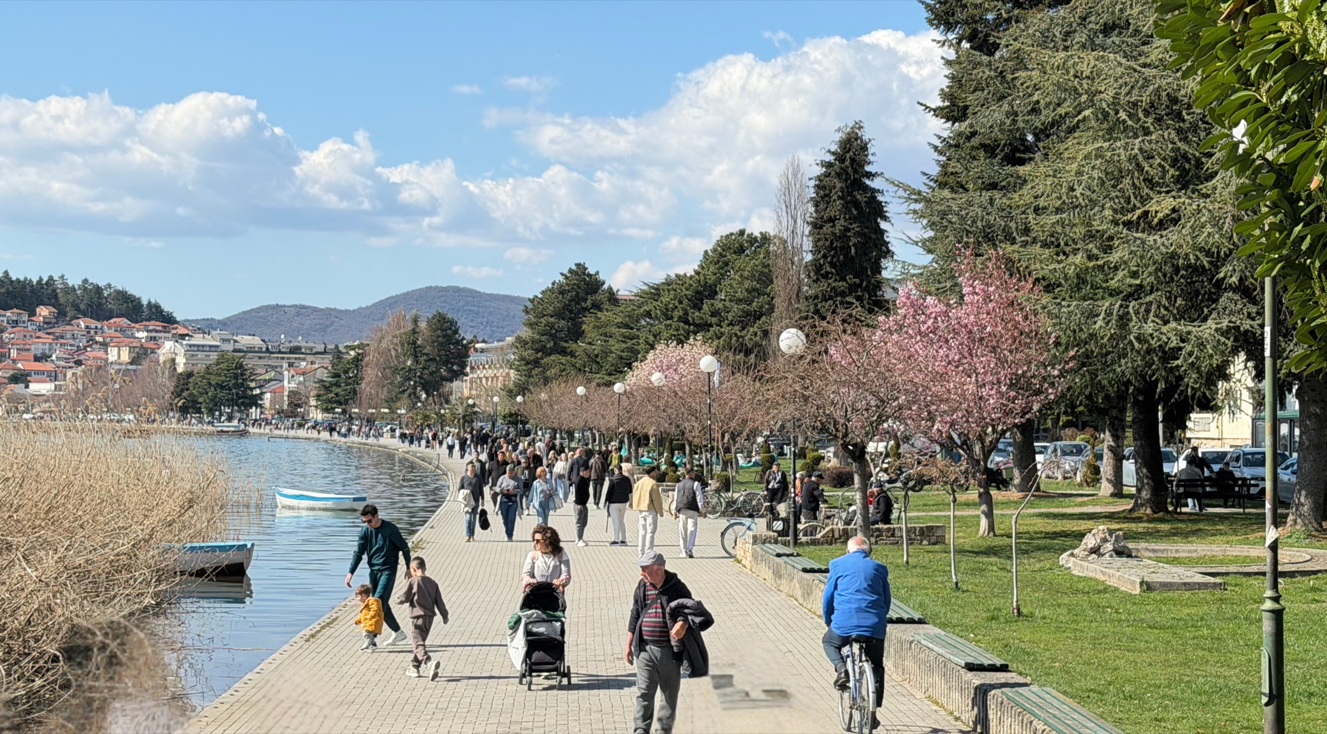 People walking along Ohrid's lakeside promenade during daily life near the water.