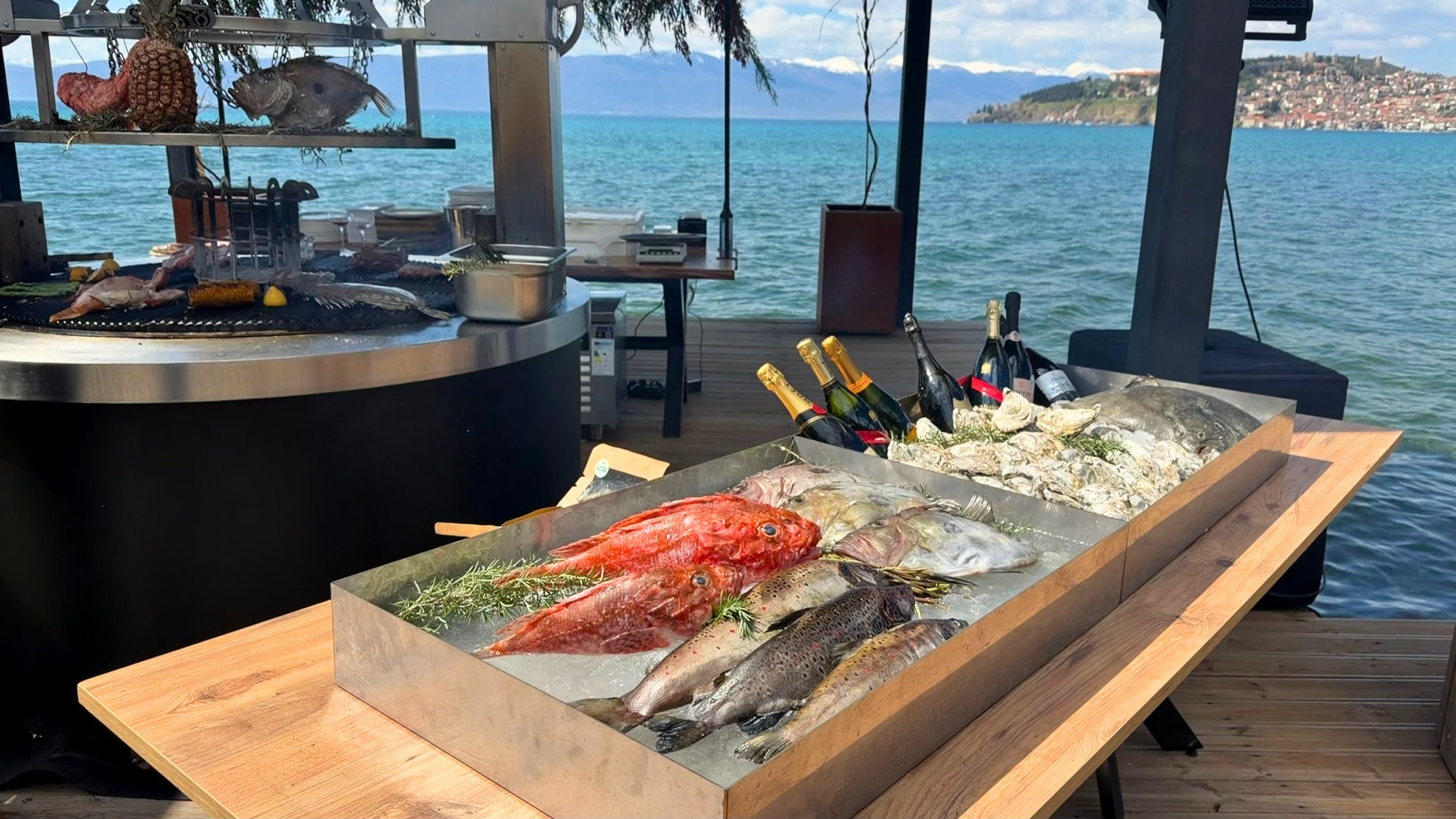 Grilled Ohrid trout presented beside Lake Ohrid with the fish visible before lunch.