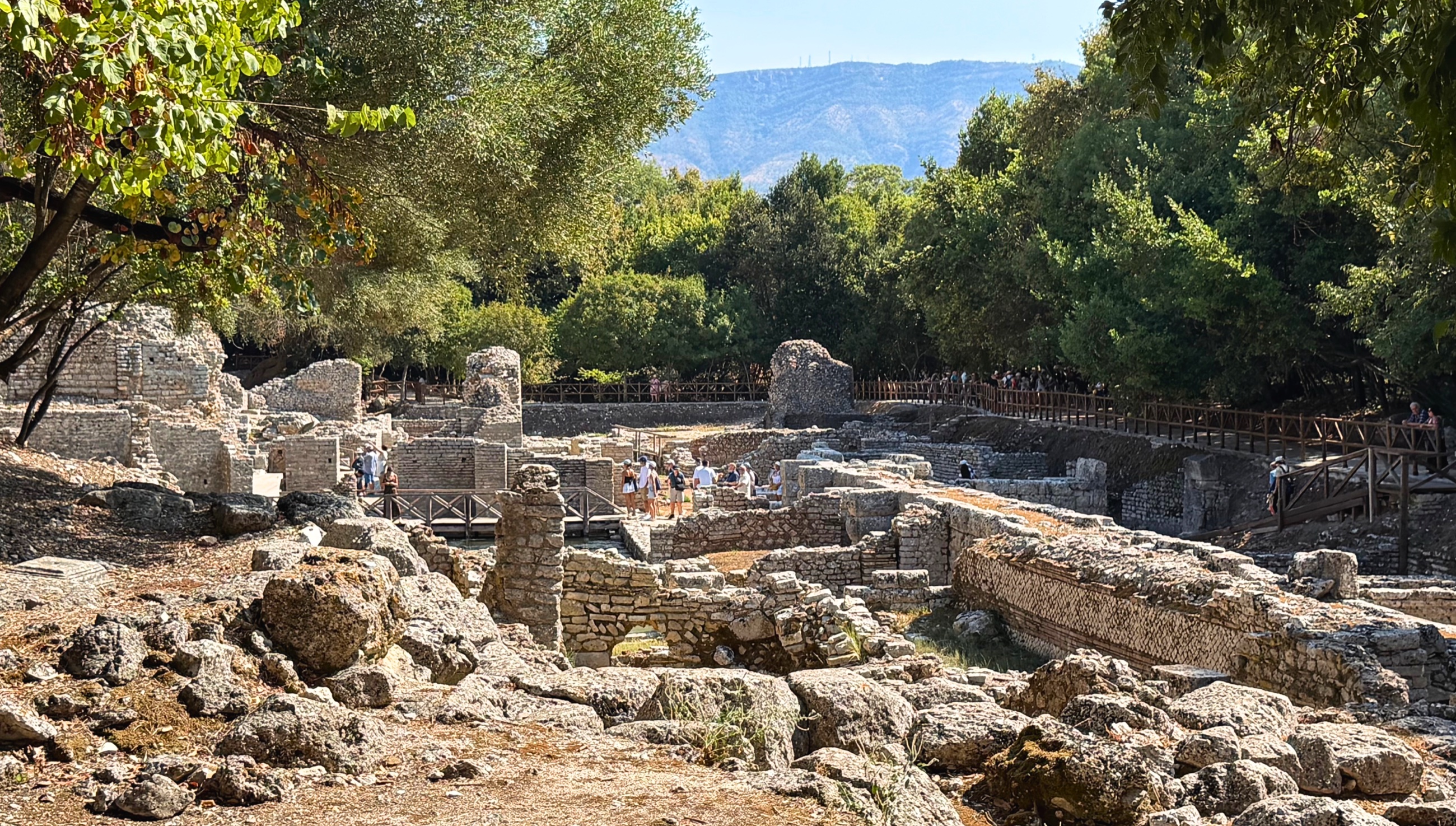 Ruins of Butrint's lower city spread among trees and stone foundations.
