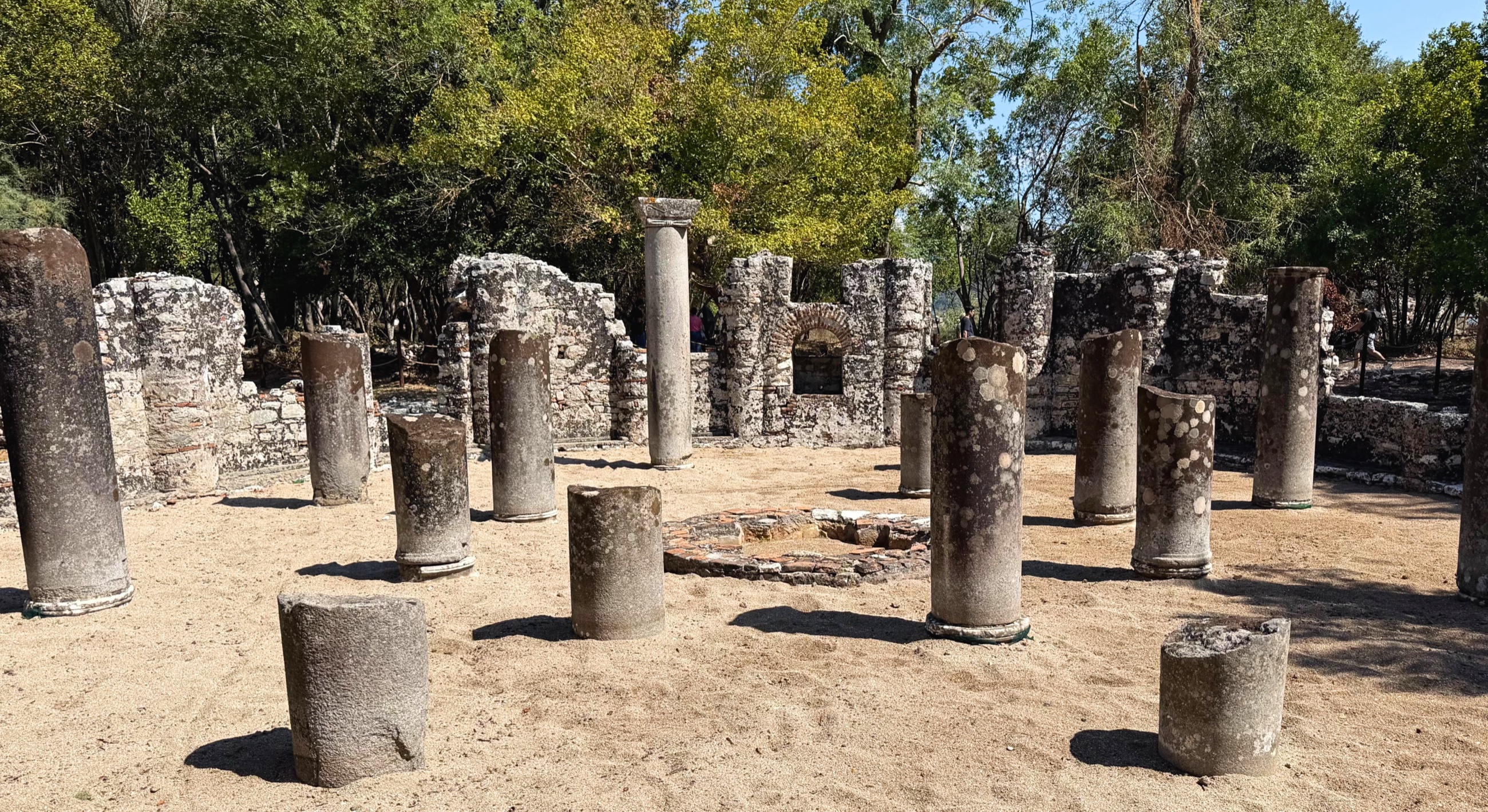 Surviving columns of Butrint's sixth-century Baptistery with its mosaic floor covered by protective sand.