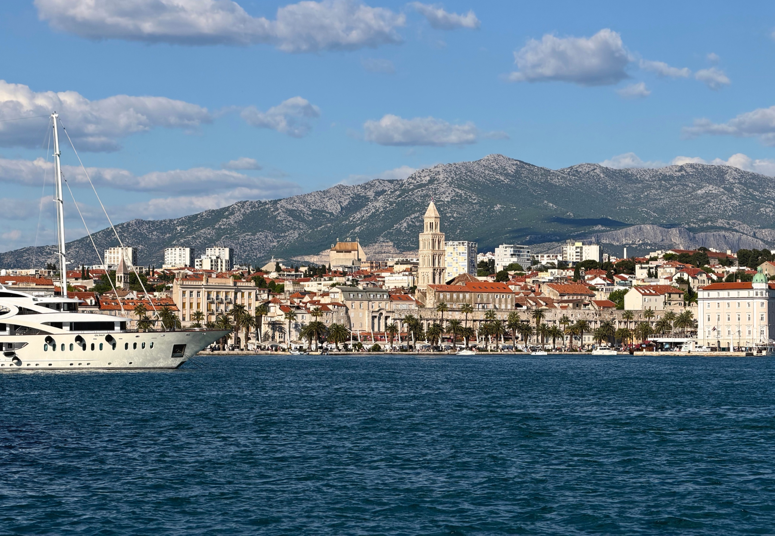 Split harbor with the Adriatic Sea in front of the city and mountains rising behind it.
