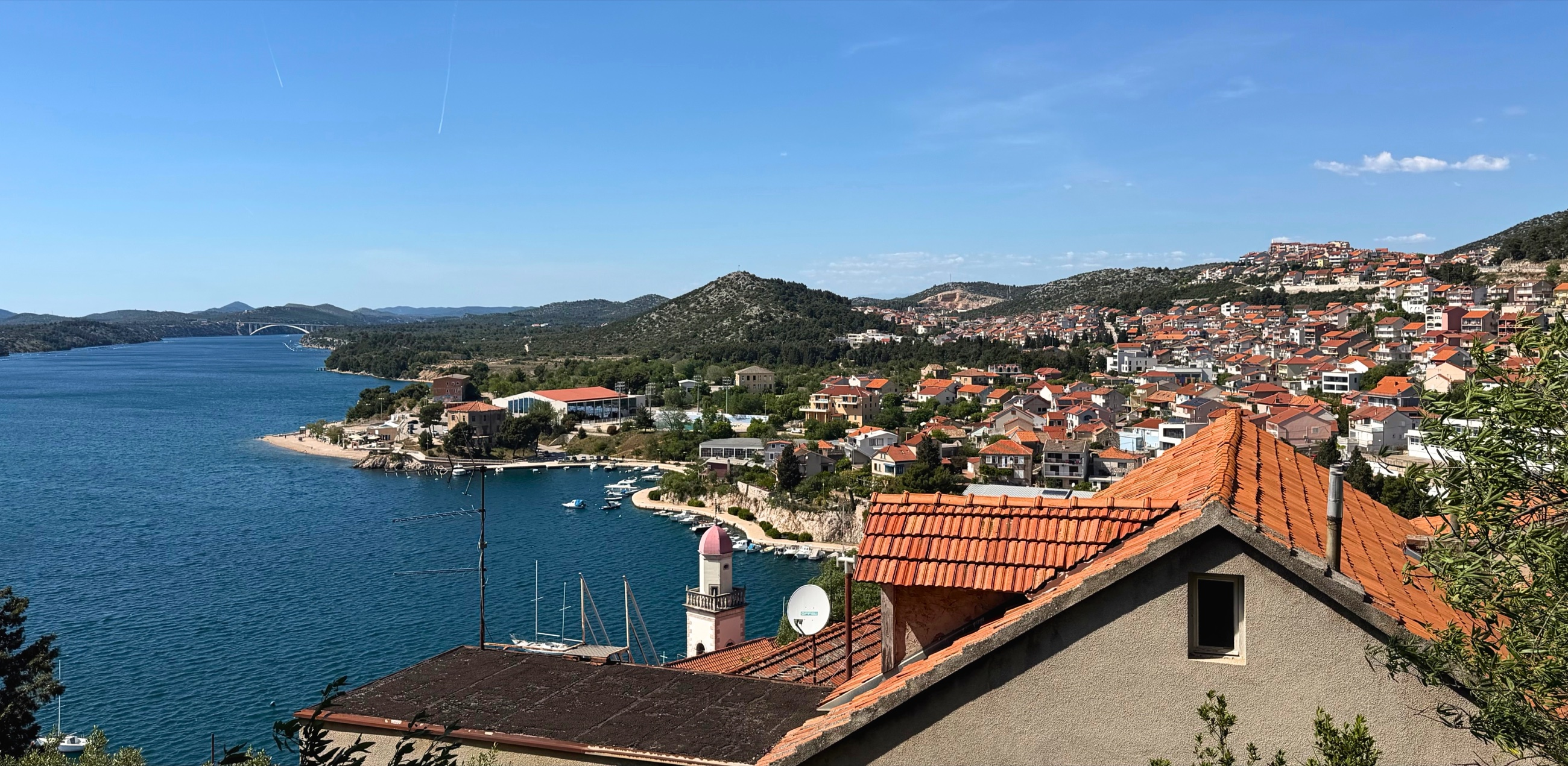 Šibenik old town from above, rising in stone tiers between the fortress and the Adriatic Sea.