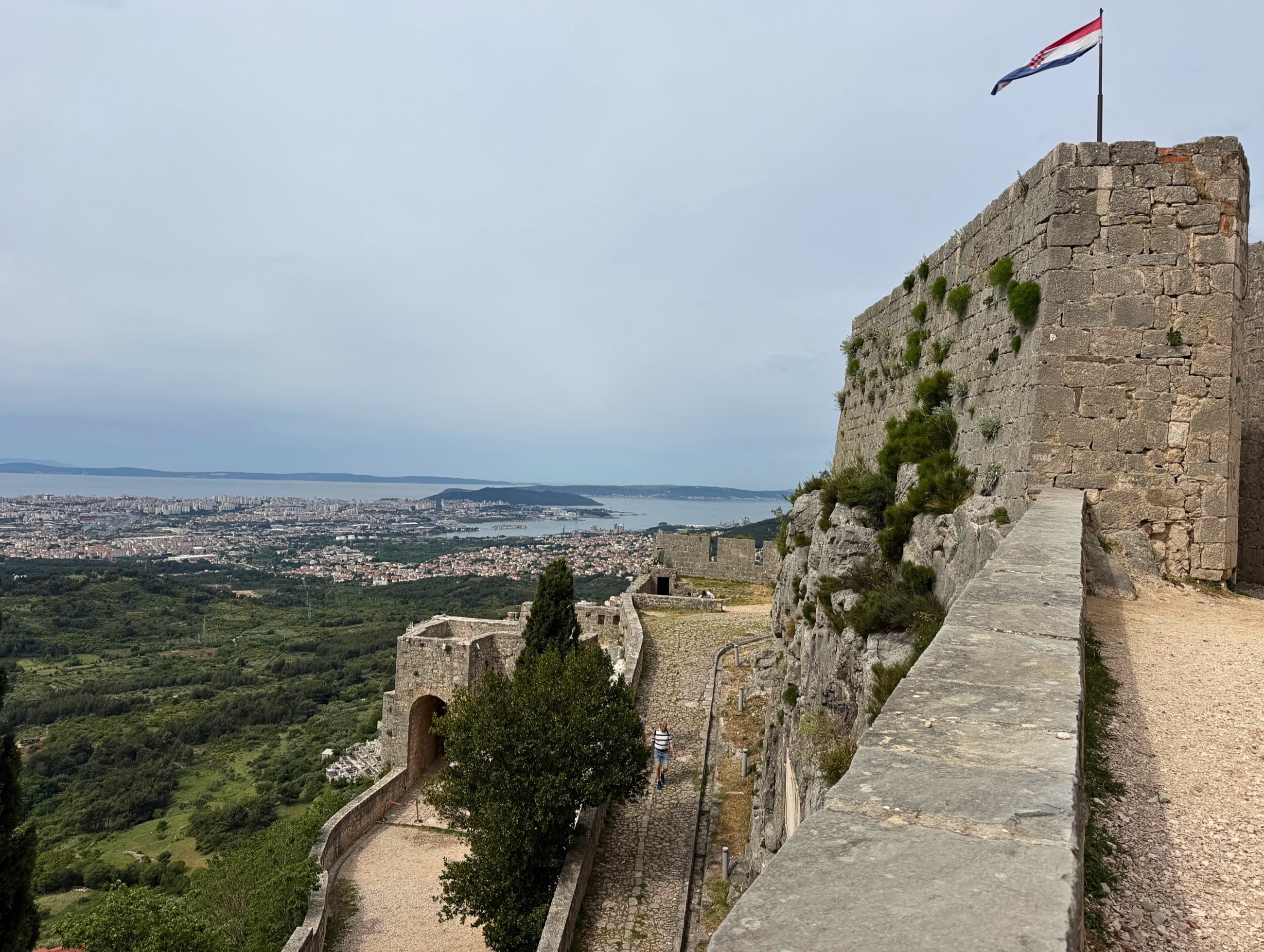 Klis Fortress above Split with stone walls, Croatian flag, and the city below