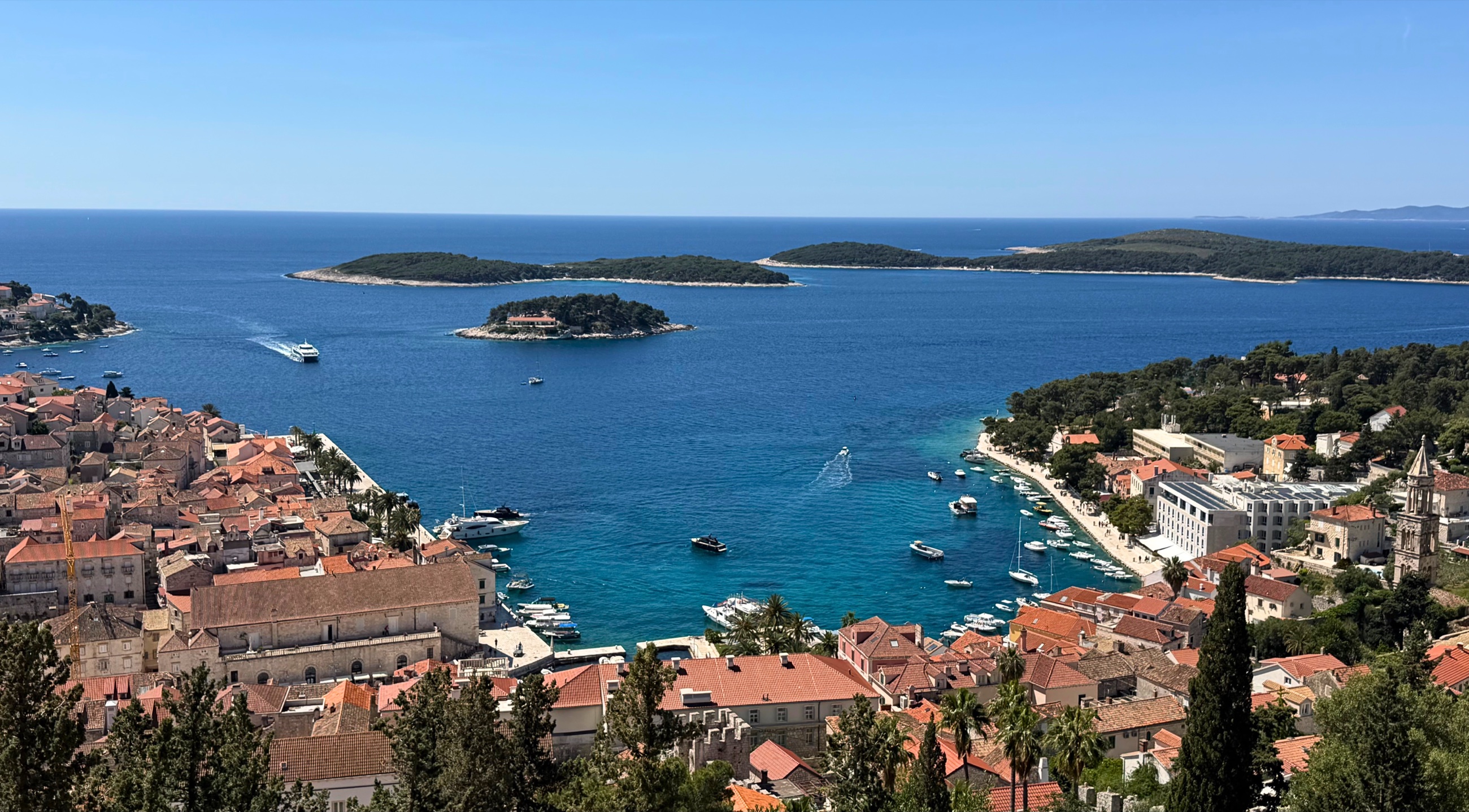 View over Hvar Town harbor, rooftops, and the Pakleni Islands from above