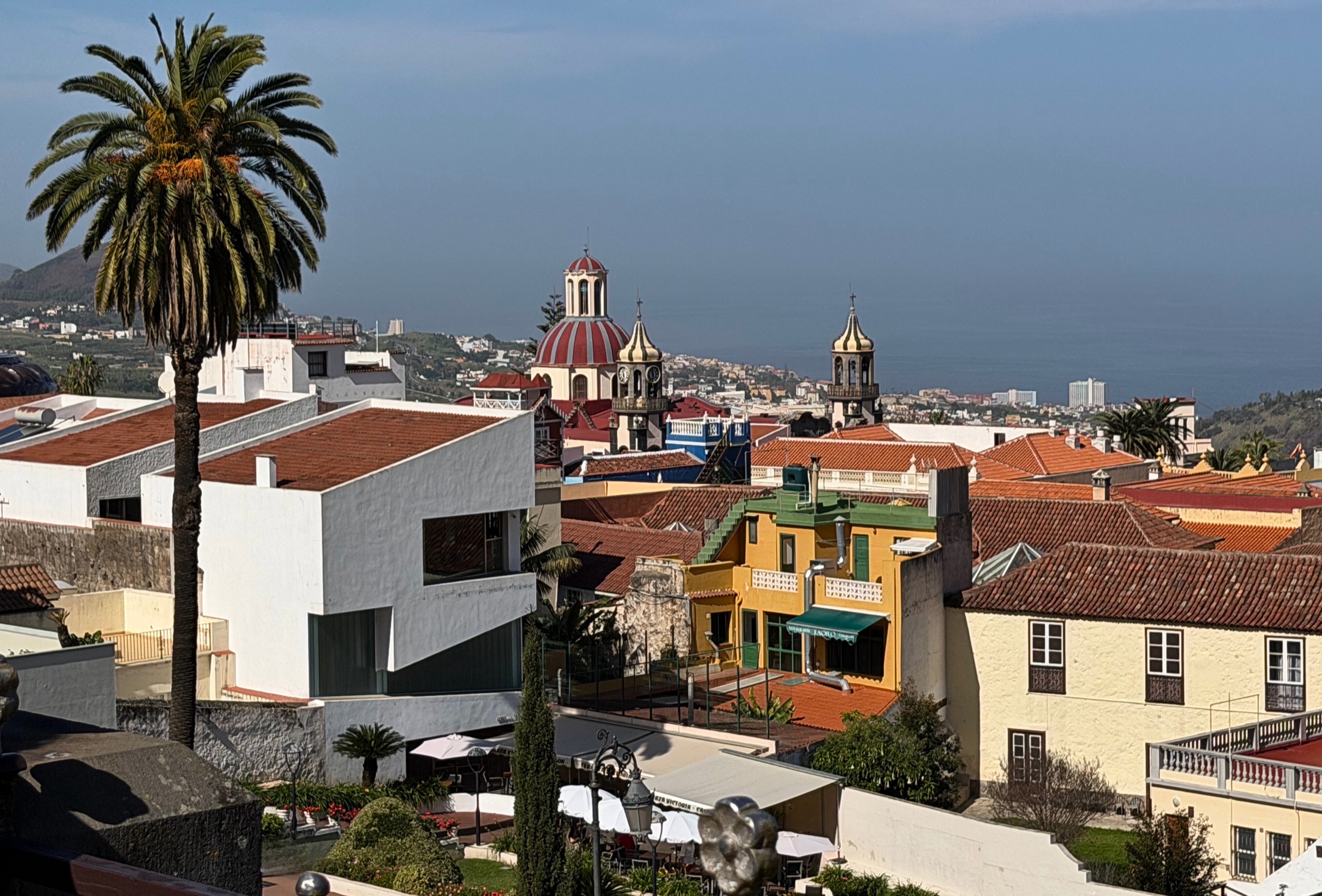 La Orotava rooftops, church towers, and the Atlantic Ocean in the distance.