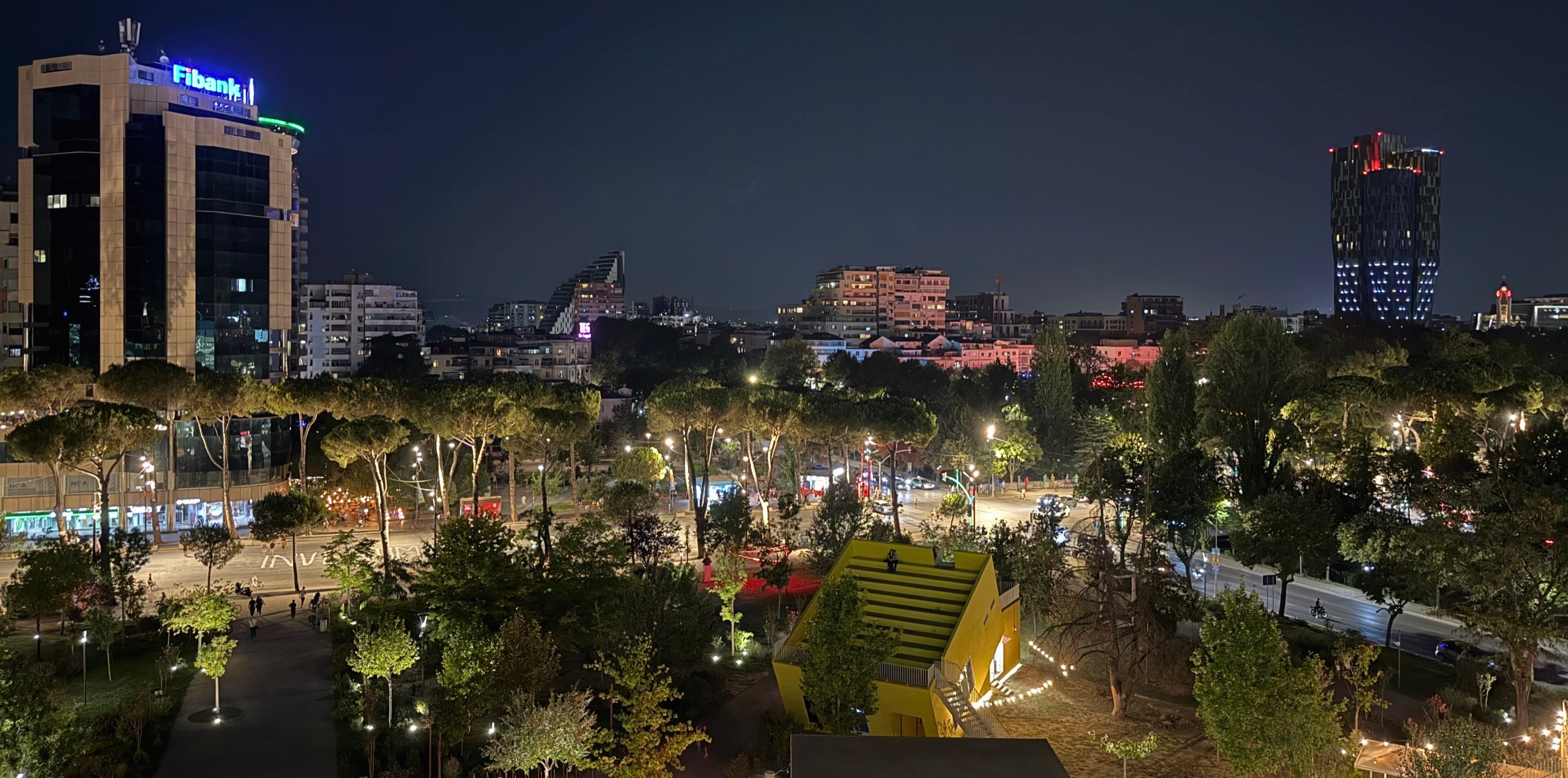Tirana after dark, with illuminated streets and modern buildings.