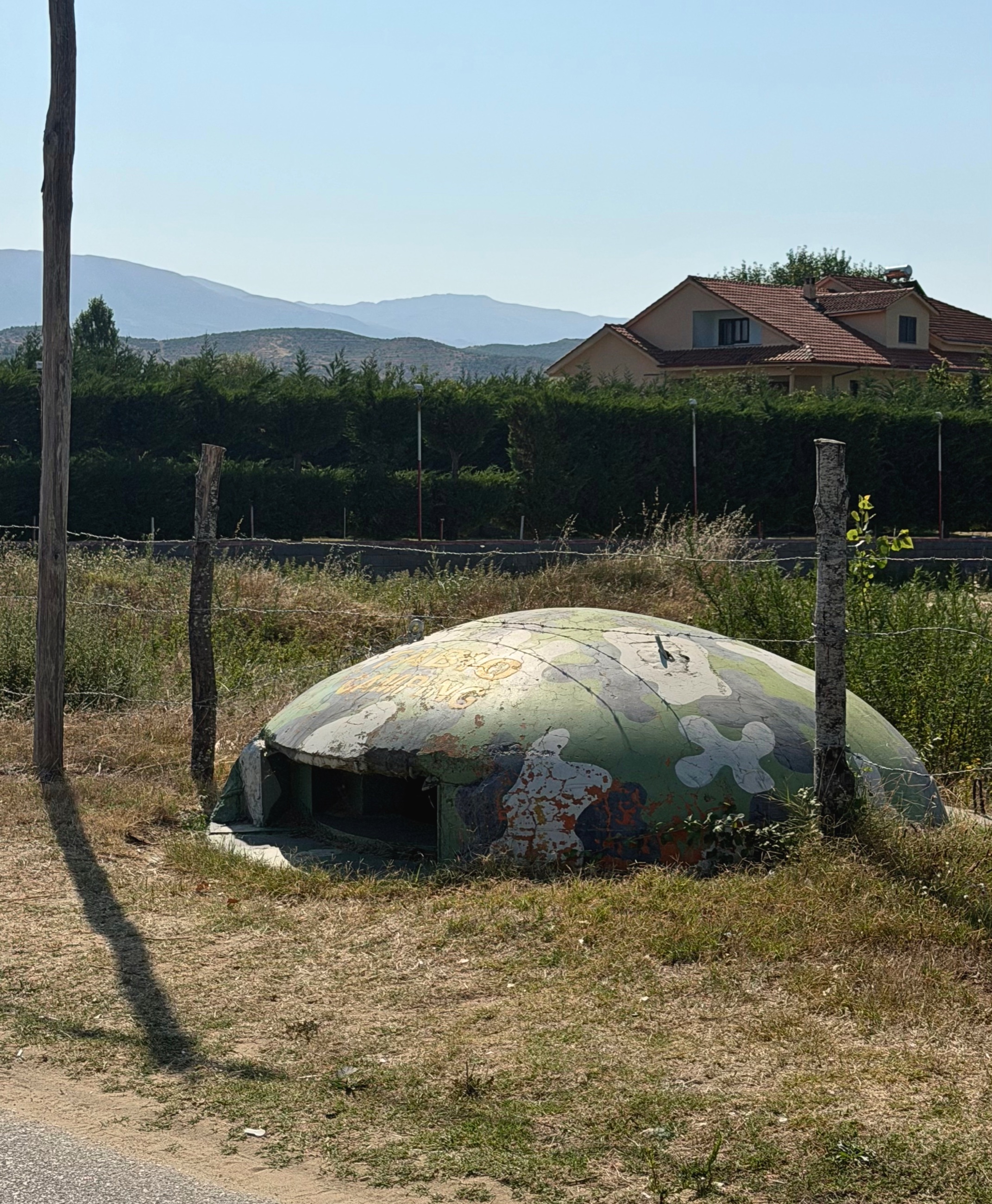 Cold War-era concrete bunkers beside the lakeside road near Pogradec.