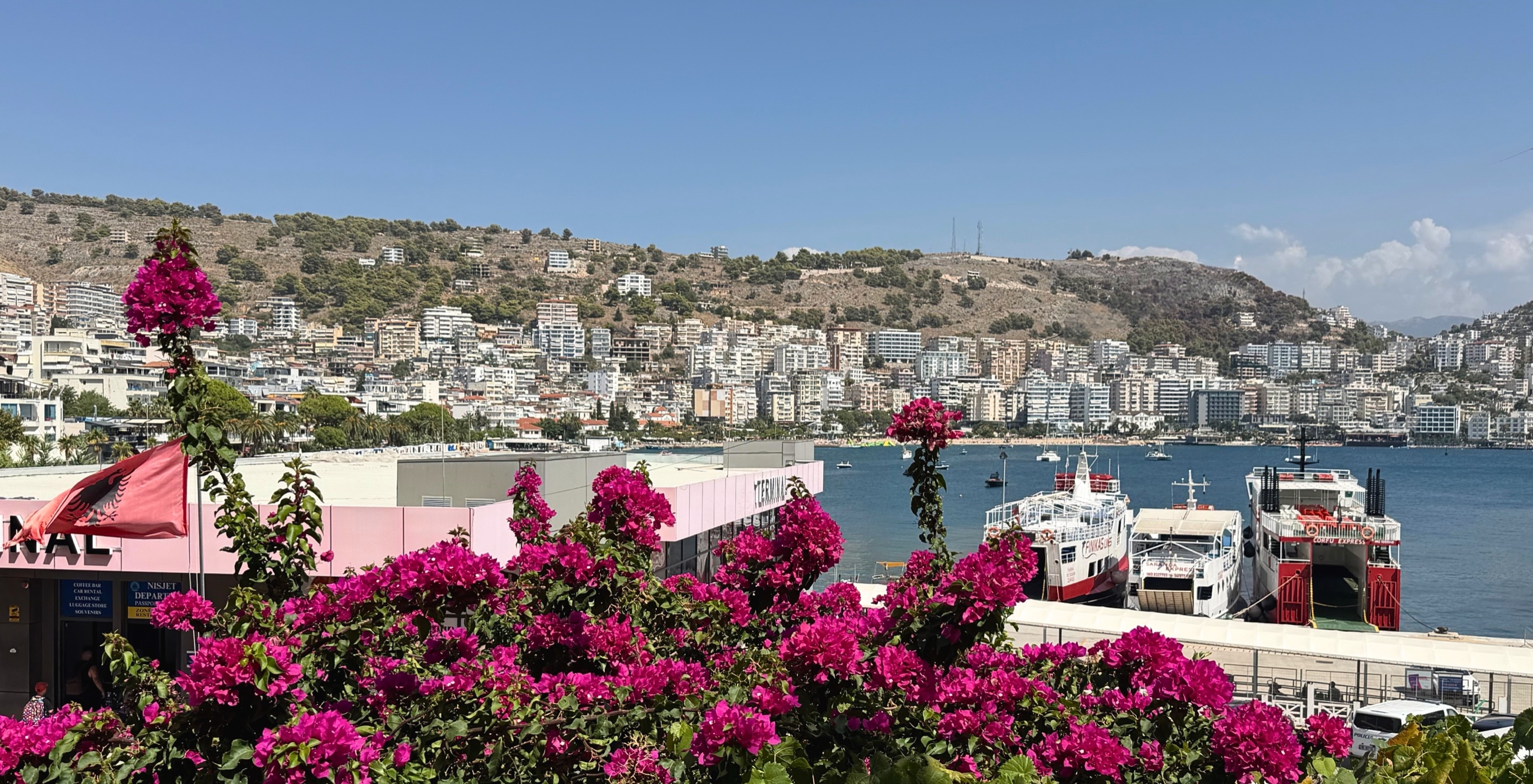 Bougainvillea above the port with Sarandë spread across the bay.